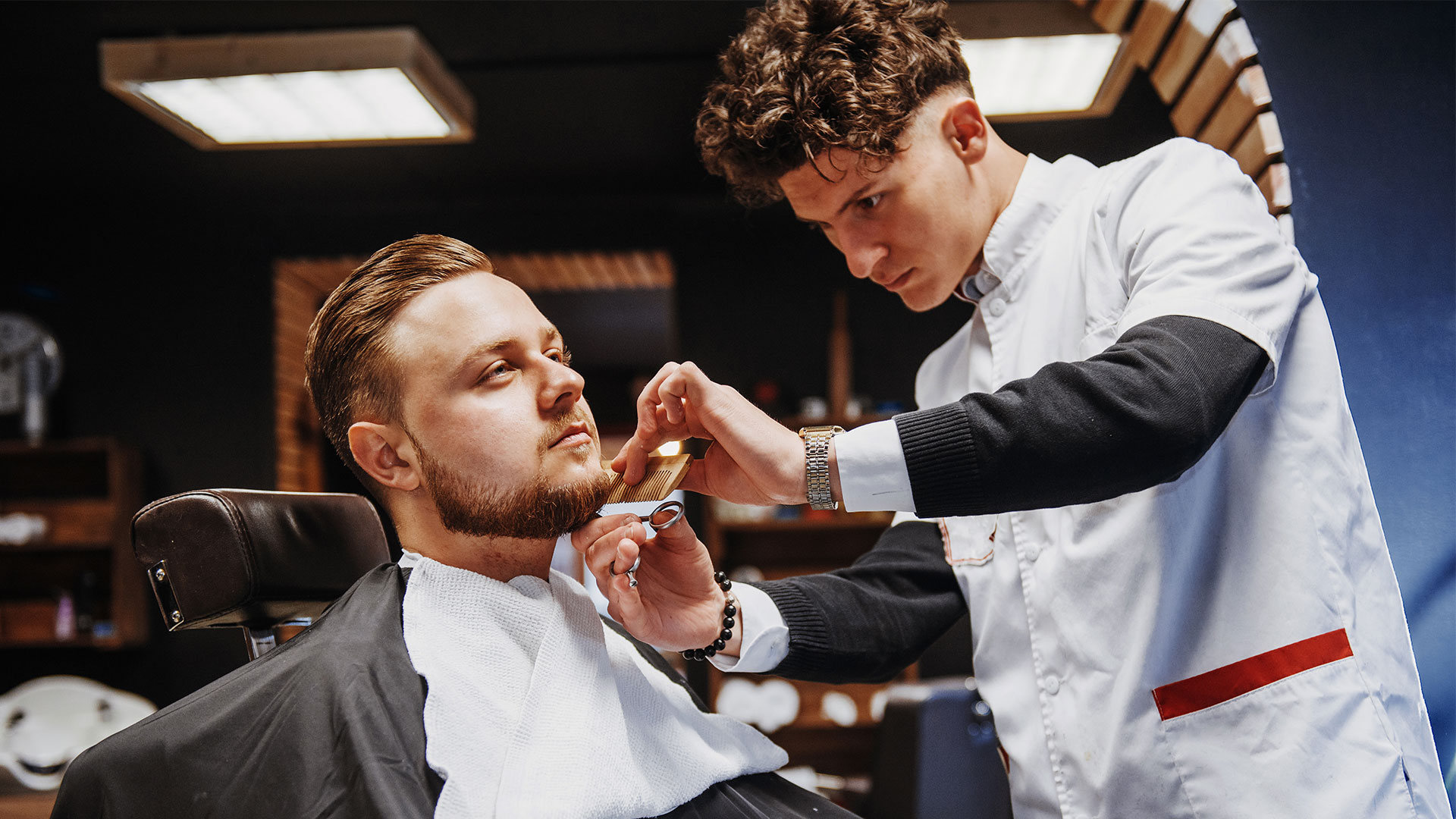 Barber shaping a client beard during a combo cut and trim