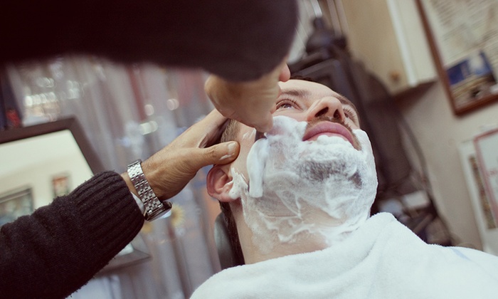 Barber applying lather for a hot towel straight razor shave