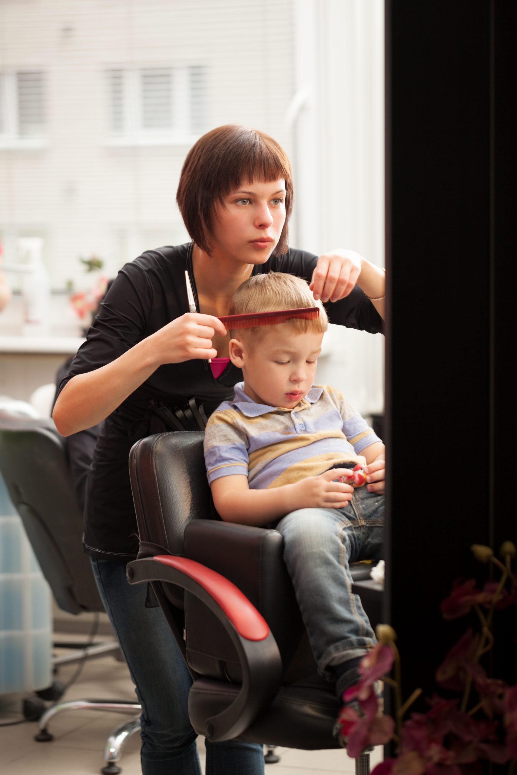 Child having his hair cut in the barber chair