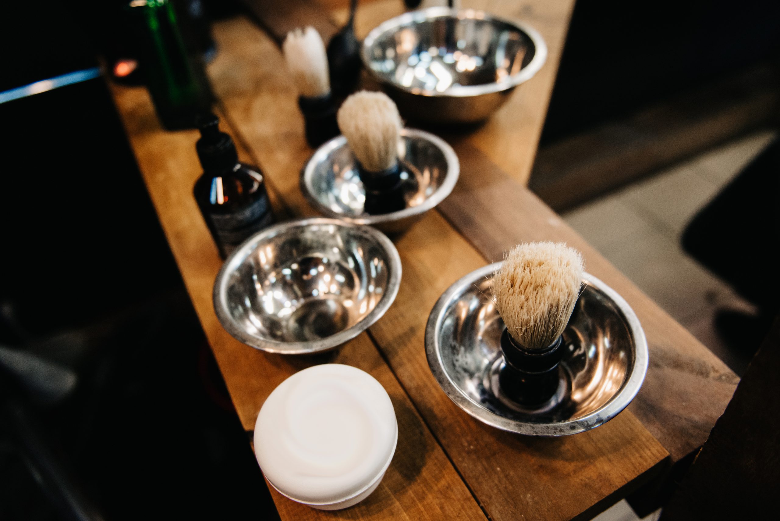 Shaving bowls and badger brushes on a wooden counter